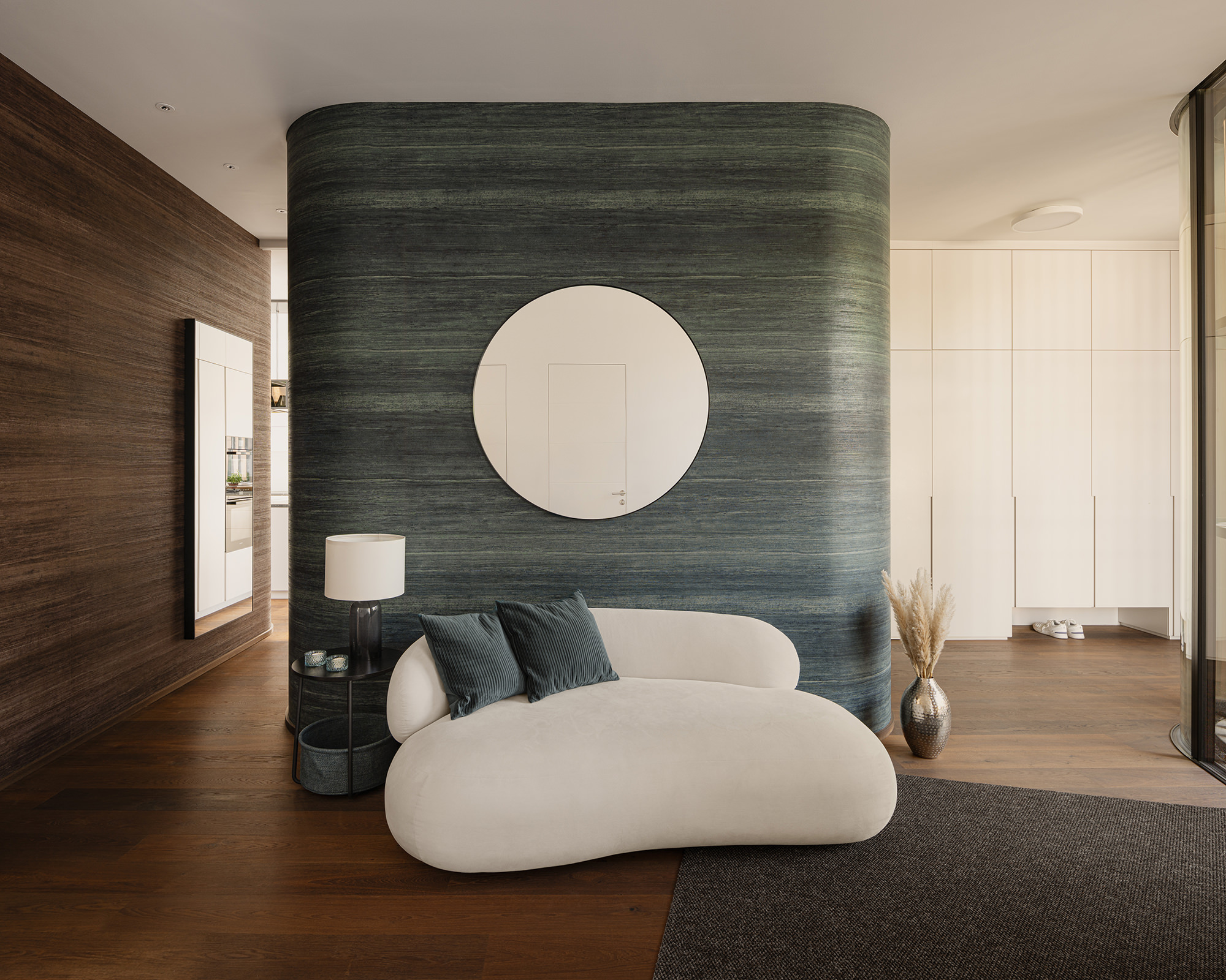 Eingangsbereich mit abgerundeten Wandecken und einer runden, kleinen Sitzgelegenheit