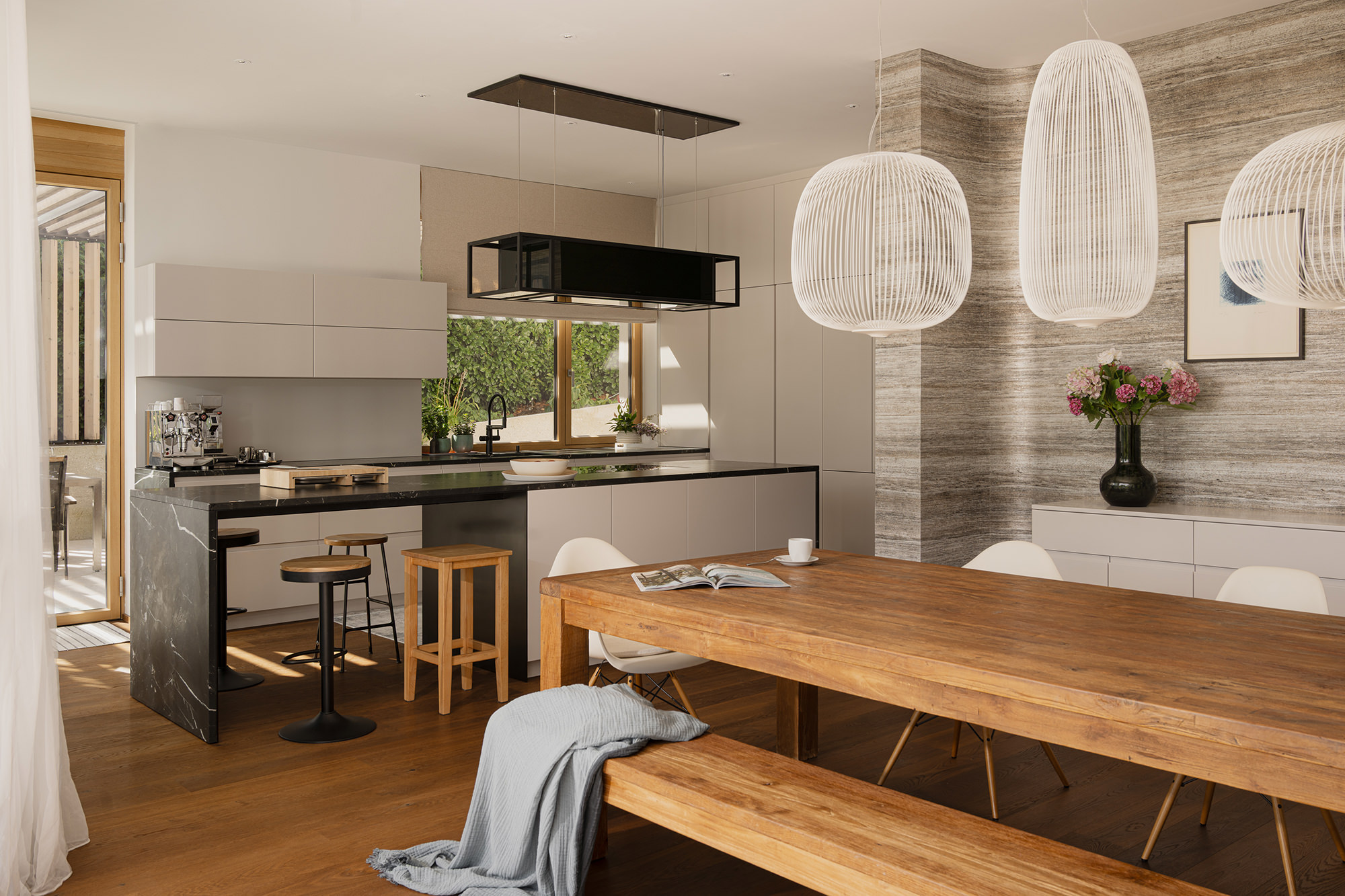 Blick von Esstisch in die Küche, welche sehr offen und schlicht eingerichtet ist