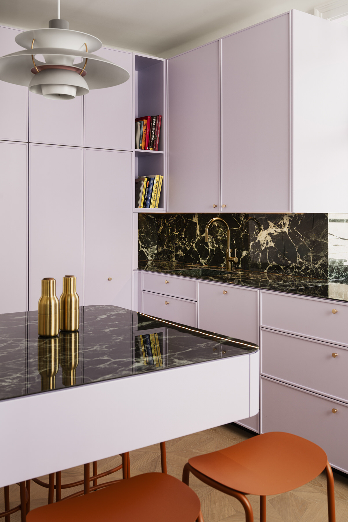 Moderne Küche mit lila Schrankfronten, dunkler Marmor-Arbeitsfläche, viel Stauraum und einer kleinen Bar-Sitzgelegenheit.