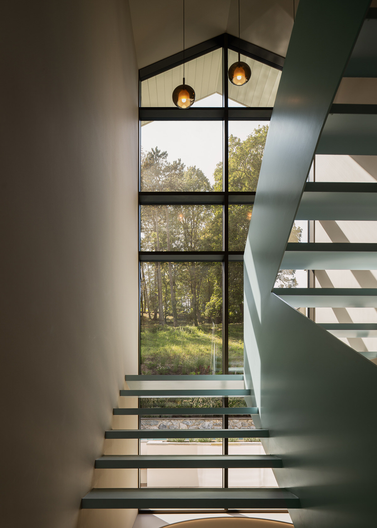 Blick durch die Fensterfront im Treppenraum, mit den Treppen im Vordergrund.