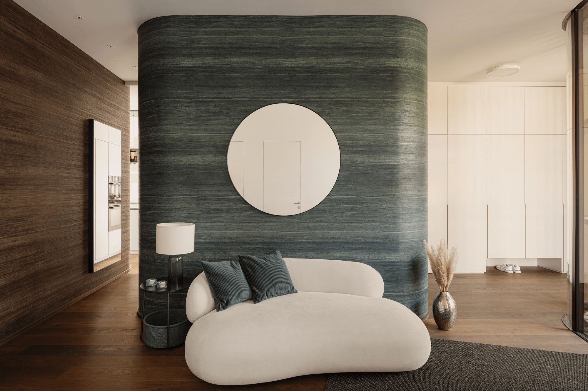 Eingangsbereich mit abgerundeten Wandecken und einer runden, kleinen Sitzgelegenheit