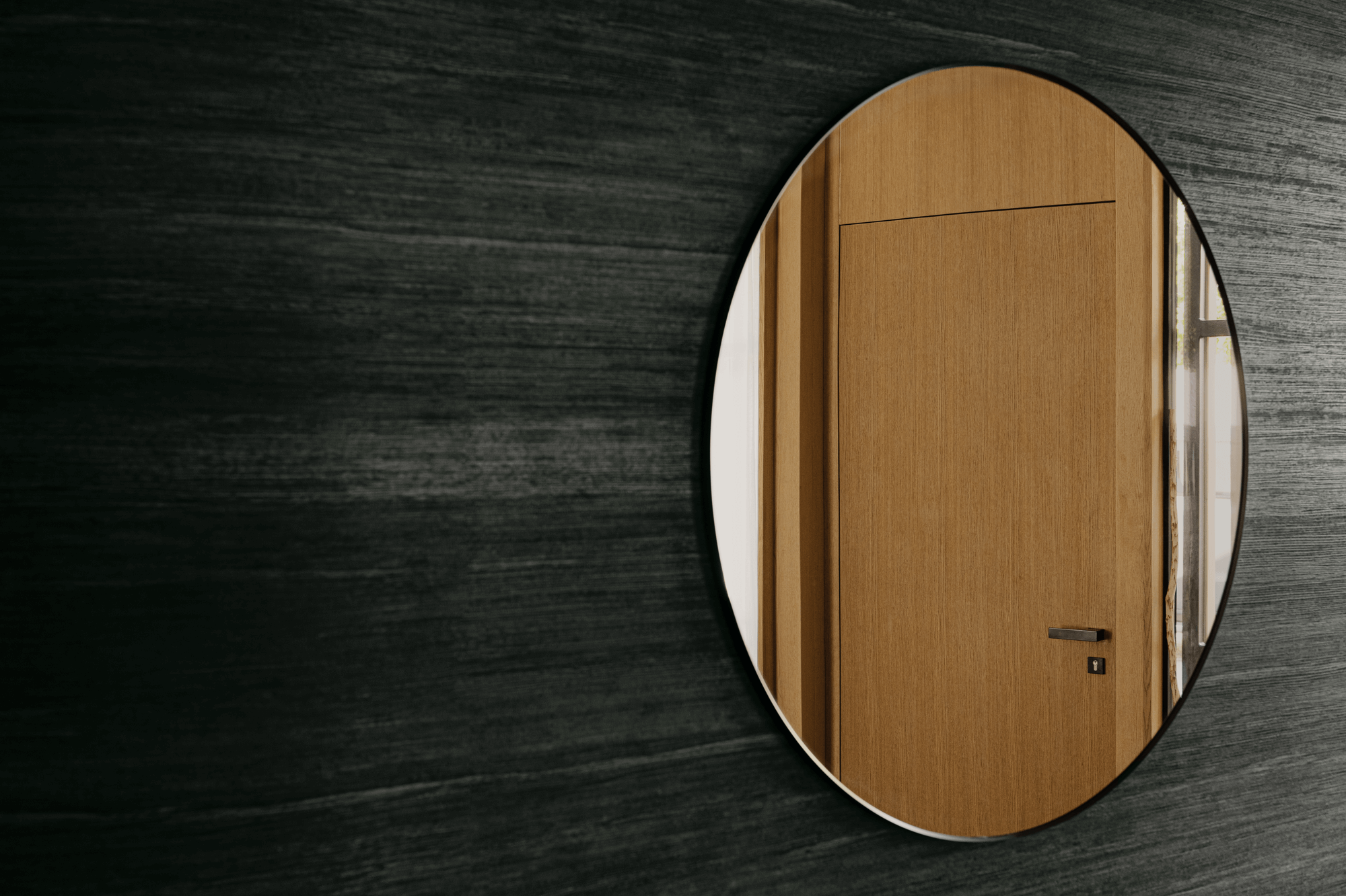 Großer runder Spiegel im Eingangsbereich welche eine Türe in Hintergrund reflektiert