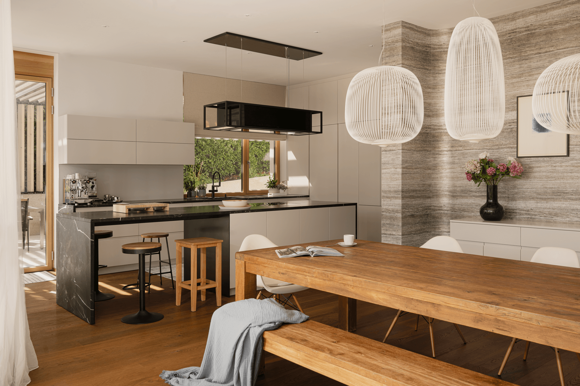 Blick von Esstisch in die Küche, welche sehr offen und schlicht eingerichtet ist